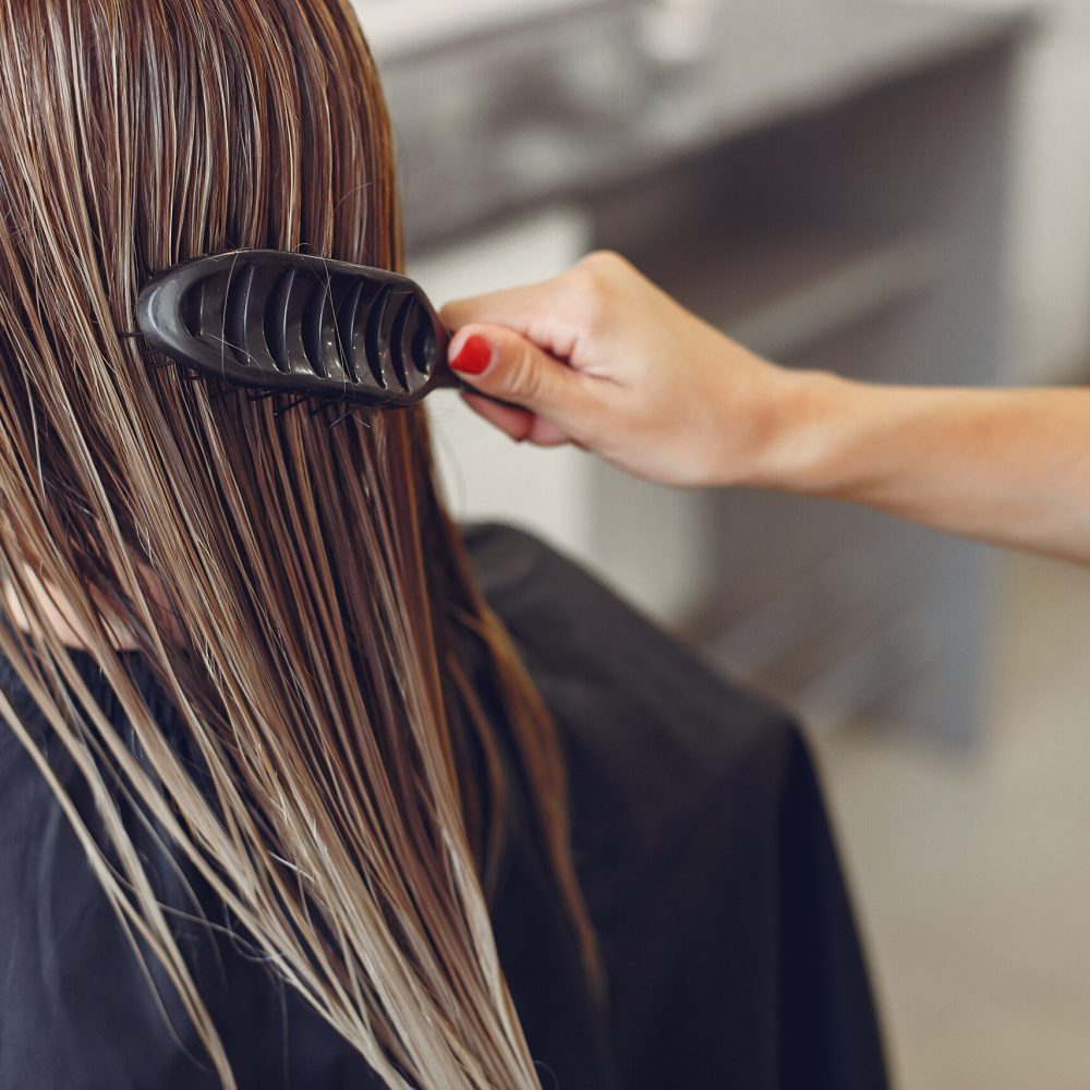 Hairdresser drying head her client. Woman in a hair salon